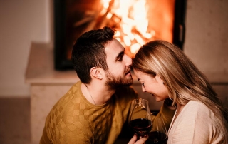 Couple in front of a fireplace.