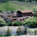 Bitterroot Ranch - Horses in the stable pens next to a river.