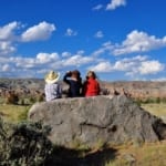 CM Ranch - Kids sitting on a rocky overlook.