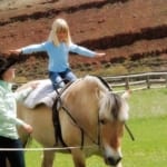 Red Rock Ranch - young girl balancing on horseback.