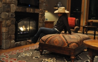 The Hideout Lodge - rancher sitting next to the fireplace.