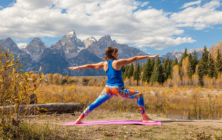 Woman doing yoga in front of the mountains during a wellness retreat in Wyoming
