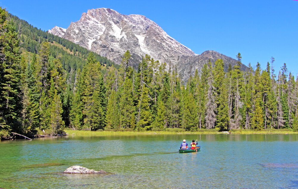 People kayaking in the mountains, one of the most popular guest ranch activities in Wyoming