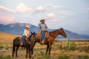Two people on horseback during a Wyoming dude ranch vacation